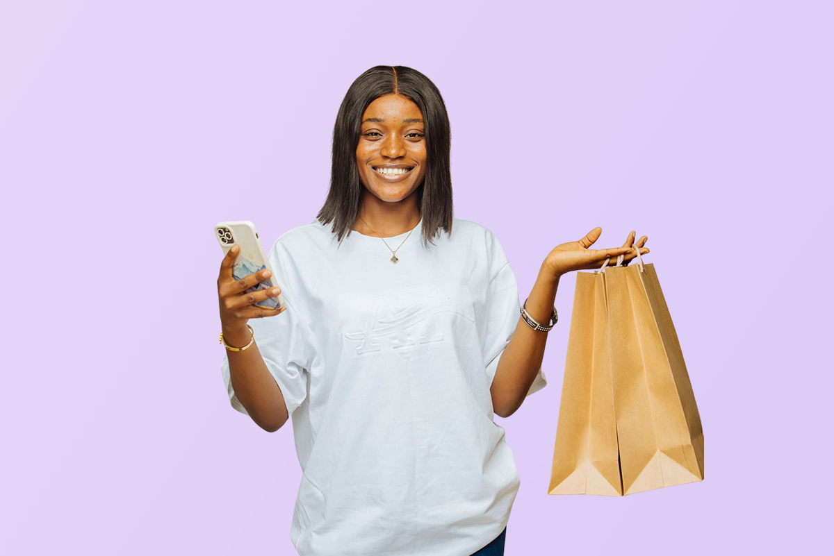 University of Abuja student smiling with phone and shopping bag on campus